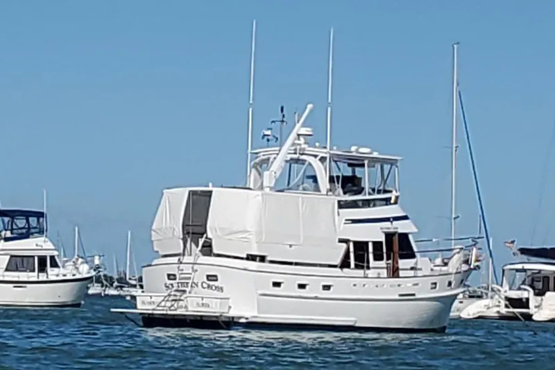 Slide: The Image of 1987 Tayana 45 Expedition Trawler anchored in a marina under clear blue skies. - 28