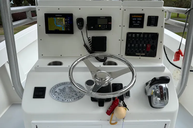 Slide: The Image of 1997 Regulator 23 boat dashboard with steering wheel, controls, and navigation equipment. - 11