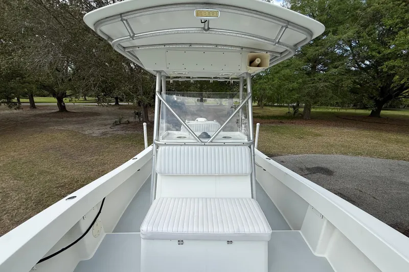 Slide: The Image of 1997 Regulator 23 boat with white seating and canopy, parked outdoors. - 17