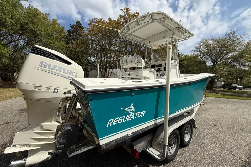 Slide: The Image of 1997 Regulator 23 boat with Suzuki outboard motor on a trailer. - 2