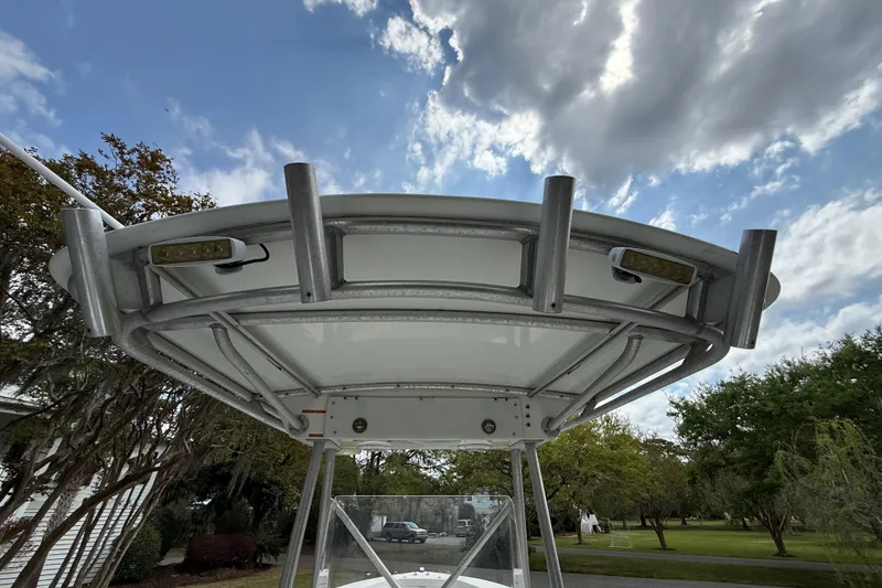 Slide: The Image of 1997 Regulator 23 boat T-top with rod holders under a cloudy sky. - 21