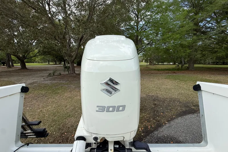 Slide: The Image of Suzuki 300 outboard motor on a 1997 Regulator 23 boat, surrounded by trees. - 23