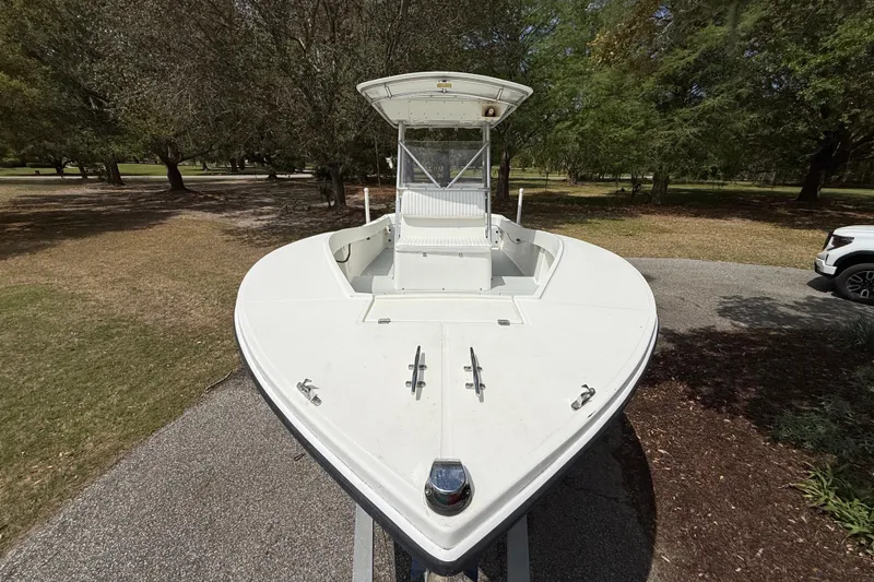 Slide: The Image of 1997 Regulator 23 boat on trailer, parked in a wooded area. - 6