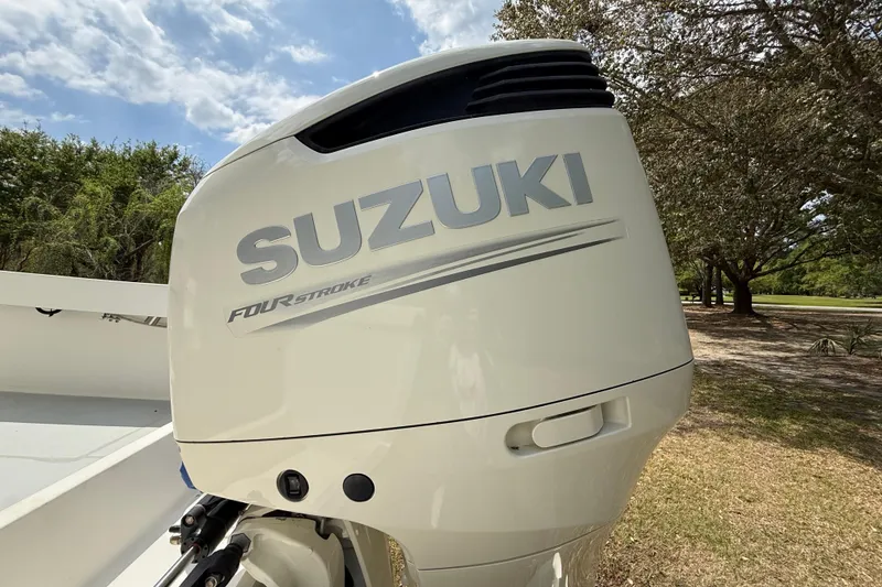 Slide: The Image of Suzuki four-stroke outboard motor on a 1997 Regulator 23 boat, outdoors. - 9