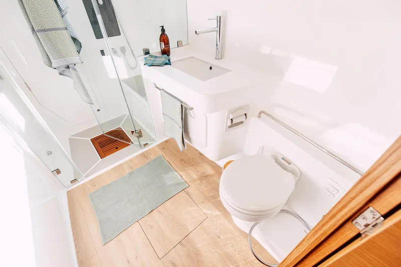 Slide: The Image of Modern bathroom in Vision 444 model, 2026, featuring shower, sink, and toilet with wooden accents. - 29