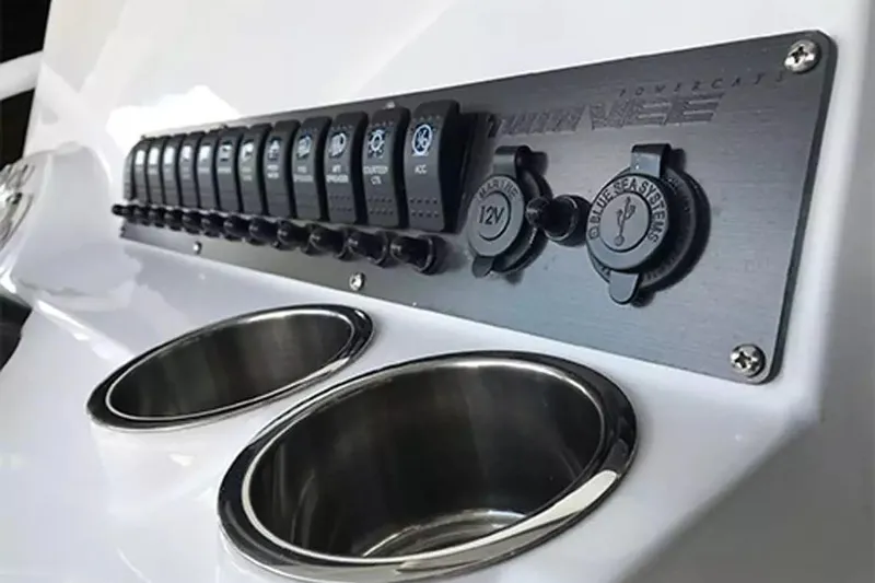 Slide: The Image of Control panel of 2026 Twin Vee 240 GFX DC boat with switches and cup holders. - 10