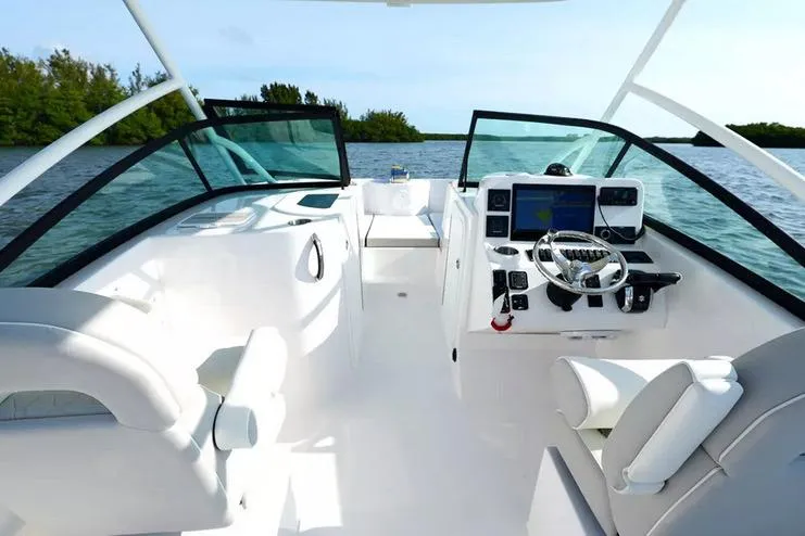 Slide: The Image of Manufacturer Provided Image: 2026 Twin Vee 240 GFX DC boat interior with modern dashboard and seating on the water. - 15