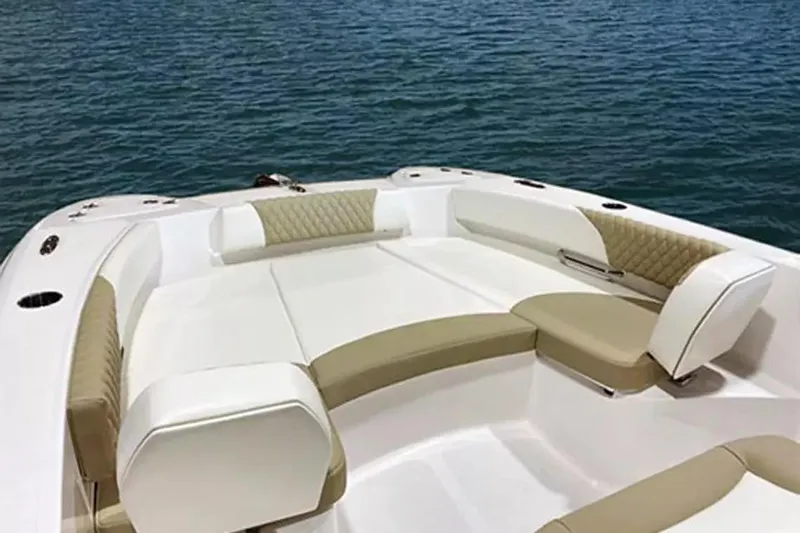 Slide: The Image of 2026 Twin Vee 240 GFX DC boat interior with beige and white seating on water. - 18
