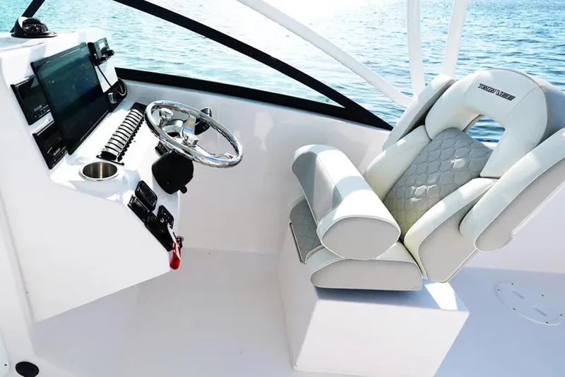 Slide: The Image of Luxurious helm of 2026 Twin Vee 240 GFX DC boat with modern controls and plush seating. - 8