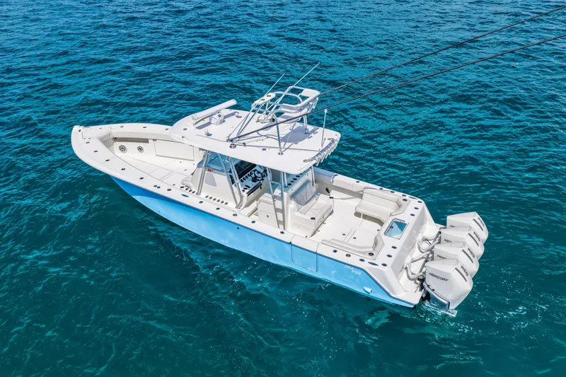 Slide: The Image of 2021 SeaVee 390B boat on clear blue ocean water, featuring multiple outboard engines. - 11