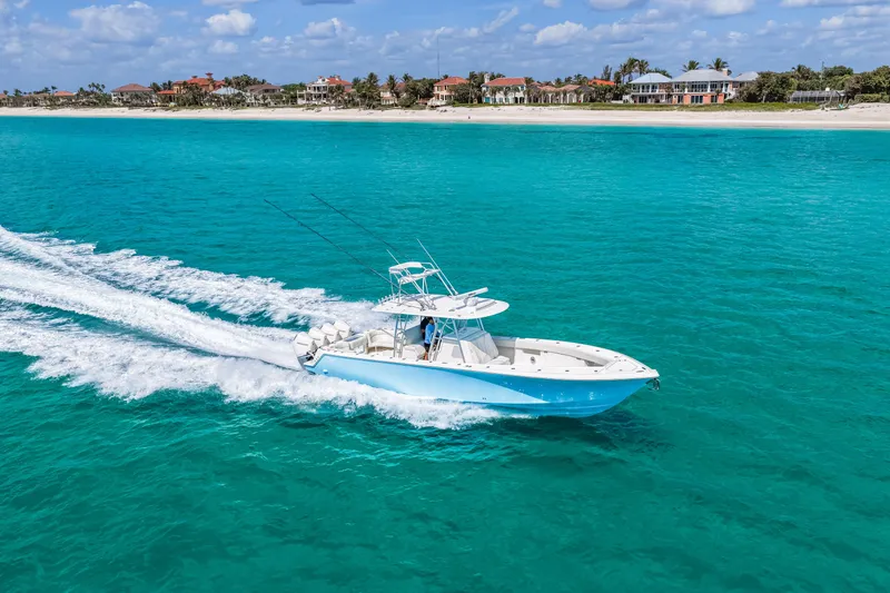 Slide: The Image of 2021 SeaVee 390B boat cruising on turquoise ocean near a sandy beach. - 23