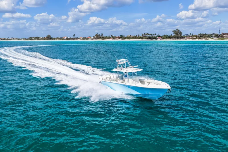 Slide: The Image of 2021 SeaVee 390B boat cruising on clear blue ocean under a partly cloudy sky. - 26