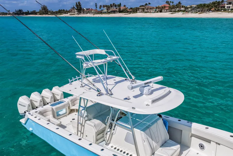 Slide: The Image of 2021 SeaVee 390B boat with multiple outboard engines on turquoise water near a sandy beach. - 4