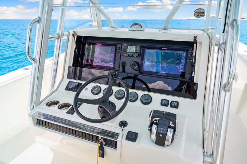 Slide: The Image of 2021 SeaVee 390B boat dashboard with navigation screens and steering wheel on open water. - 45