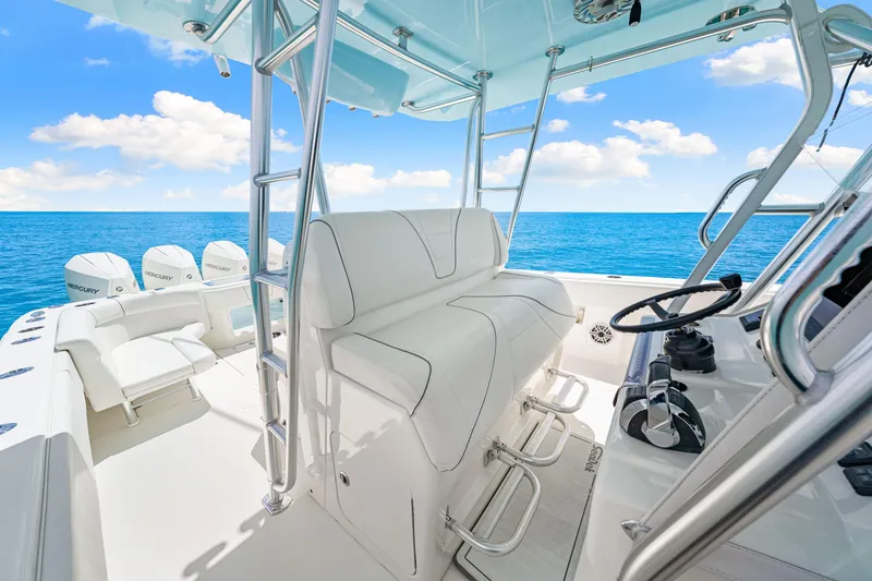 Slide: The Image of 2021 SeaVee 390B boat interior with white seating, steering wheel, and ocean view. - 46