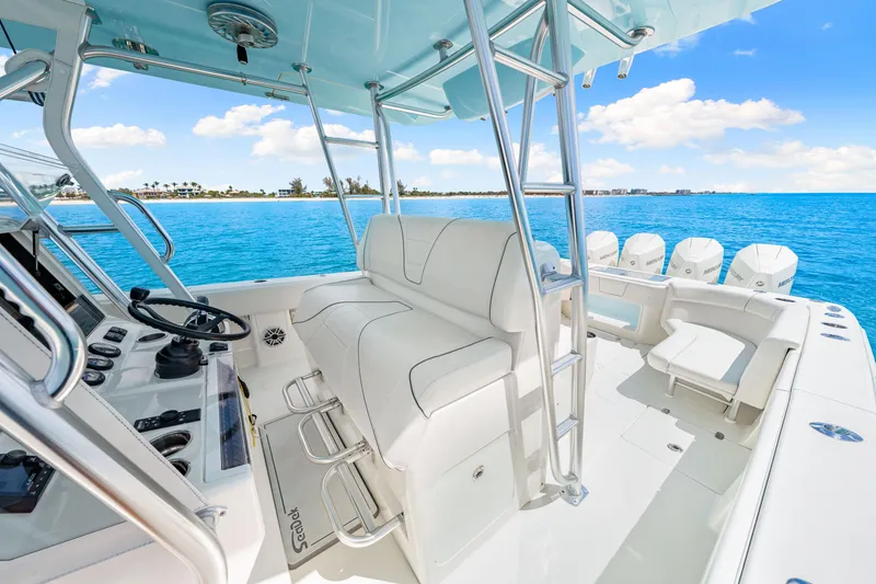Slide: The Image of 2021 SeaVee 390B boat interior with helm, seating, and multiple outboard engines on blue water. - 47