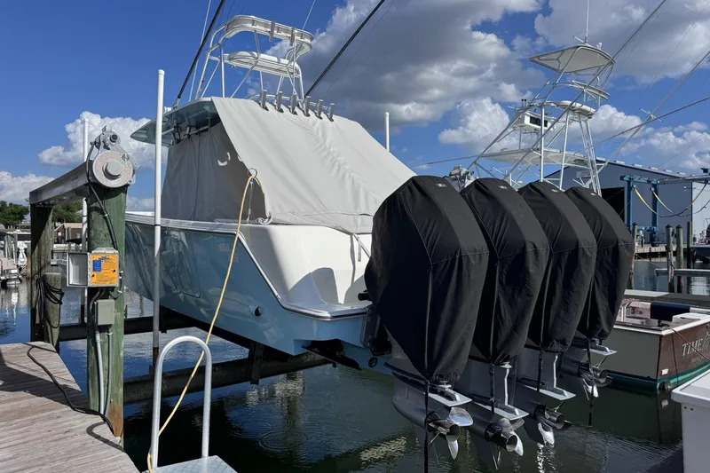 Slide: The Image of 2021 SeaVee 390B boat with covered engines docked at a marina under a partly cloudy sky. - 70