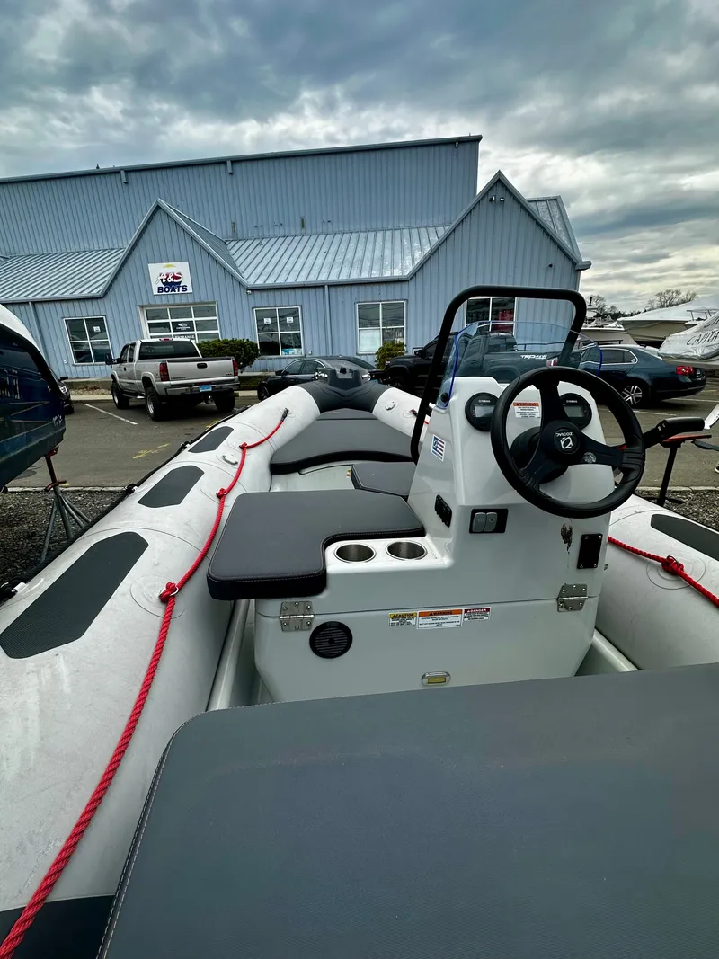 Slide: The Image of Zodiac Open 4.8 boat 2023 in front of a blue building. - 3