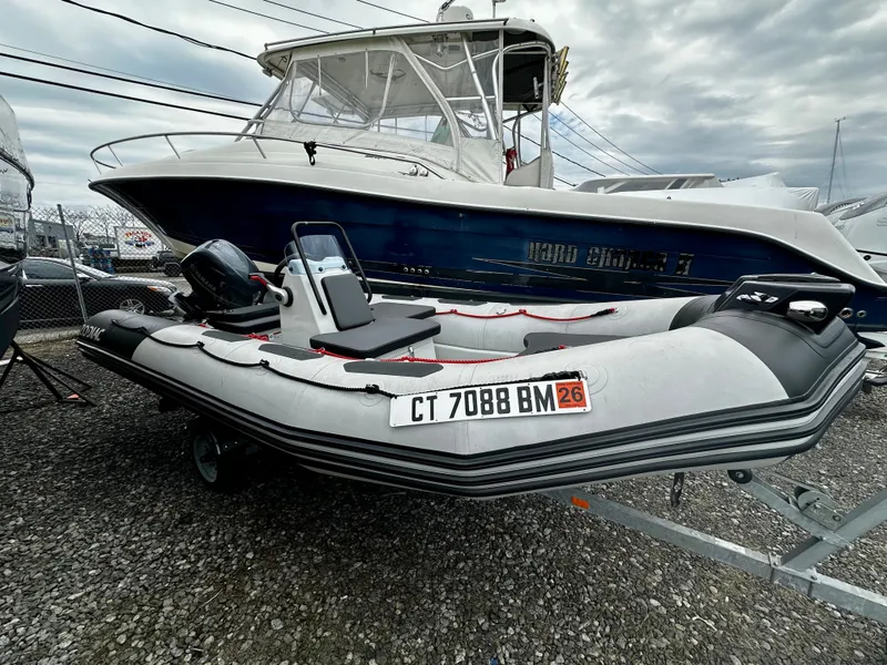Slide: The Image of 2023 Zodiac Open 4.8 inflatable boat on trailer, parked outdoors. - 5