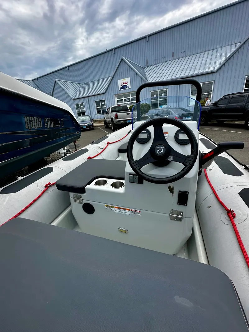 Slide: The Image of 2023 Zodiac Open 4.8 boat outdoors in front of a building. - 6