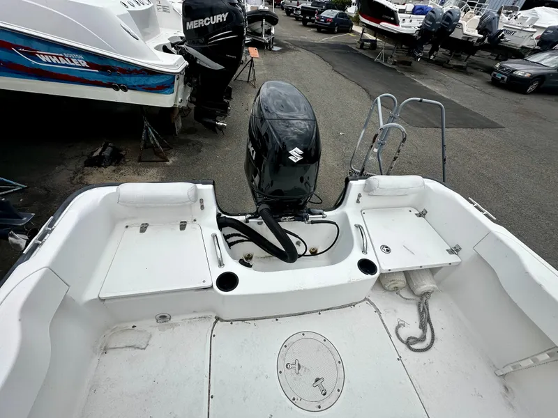 Slide: The Image of 2004 Boston Whaler 190 Nantucket with outboard motor in a parking lot. - 4