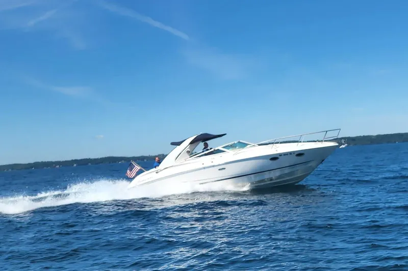 Slide: The Image of 2002 Powerquest 320 SC boat cruising on a sunny day with American flag. - 2