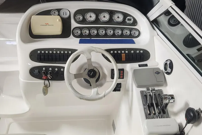 Slide: The Image of 2002 Powerquest 320 SC boat dashboard with steering wheel and control panel. - 4