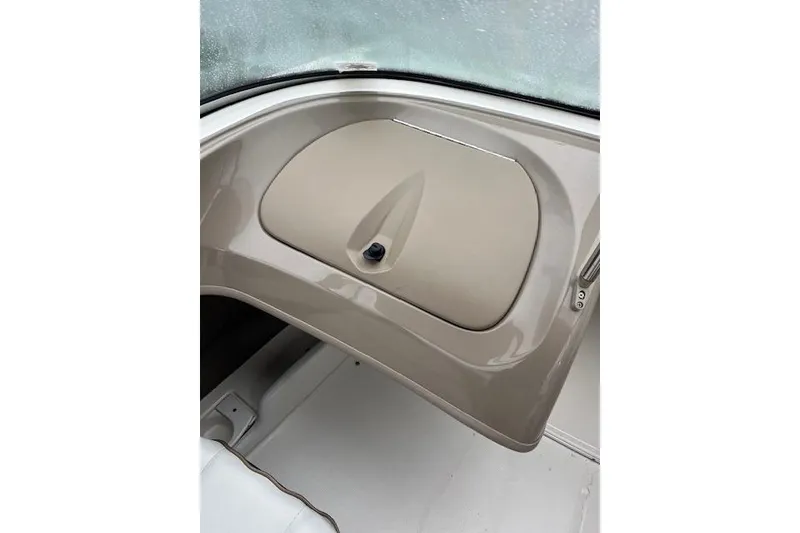 Slide: The Image of 2003 Bayliner 205 Classic boat interior detail with beige dashboard and storage compartment. - 10
