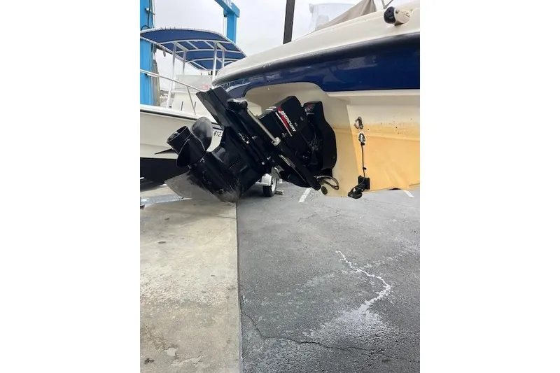 Slide: The Image of 2003 Bayliner 205 Classic boat with visible outboard motor in a marina setting. - 14
