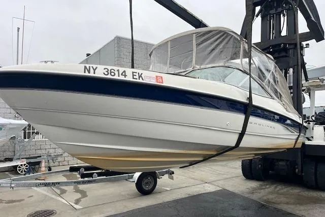 Slide: The Image of 2003 Bayliner 205 Classic boat on a lift, showcasing sleek design and registration number. - 16