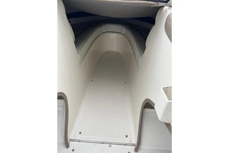 Slide: The Image of Interior view of a 2003 Bayliner 205 Classic boat cabin, showcasing clean white surfaces. - 5