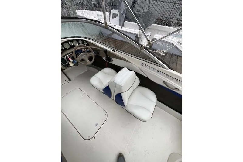 Slide: The Image of Interior of a 2003 Bayliner 205 Classic boat with white seating and steering wheel. - 7