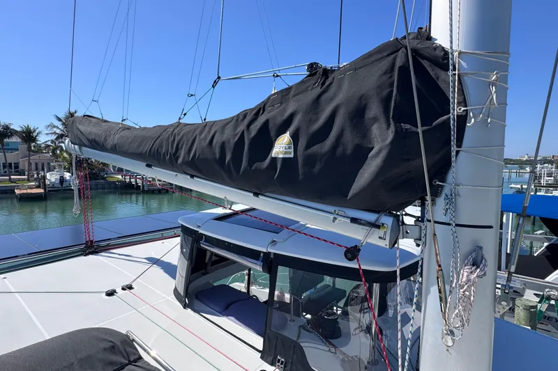 Slide: The Image of 2018 Lagoon 42 sailboat with covered mainsail, docked in a sunny marina. - 14