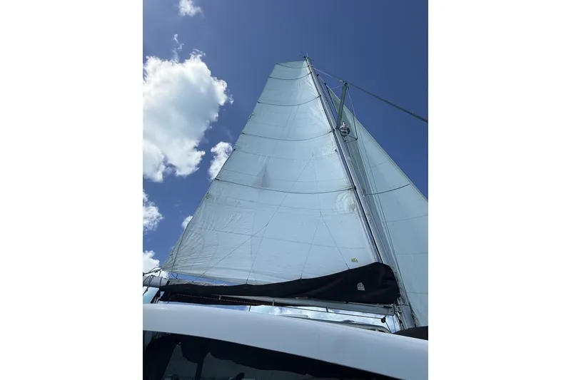Slide: The Image of Sailing yacht Lagoon 42, 2018 model, with sails unfurled against a blue sky. - 2