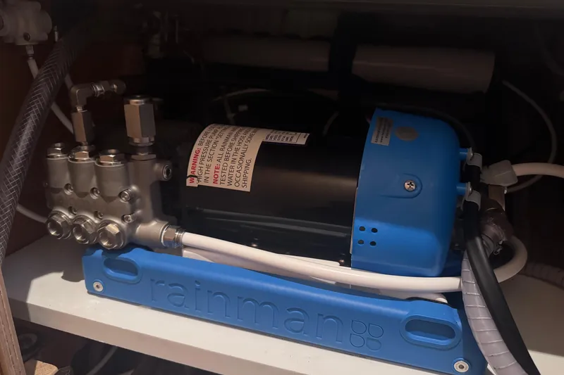 Slide: The Image of Rainman watermaker installed in a 2018 Lagoon 42 yacht, featuring blue casing and connected hoses. - 21