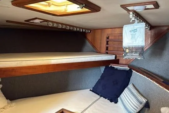 Slide: The Image of Interior cabin of 1986 Topaz 32 Express boat with wooden bunk beds and cozy decor. - 10