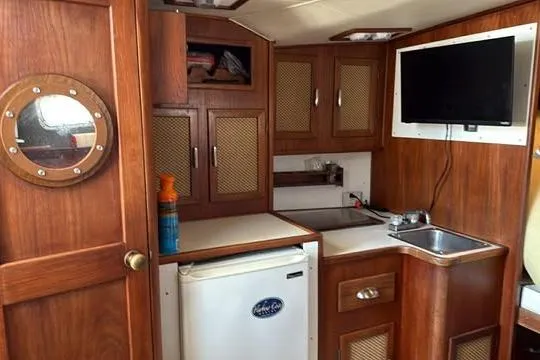 Slide: The Image of Interior of 1986 Topaz 32 Express boat with kitchenette and porthole. - 12