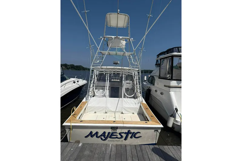 Slide: The Image of 1986 Topaz 32 Express boat named "Majestic" docked at a marina. - 2
