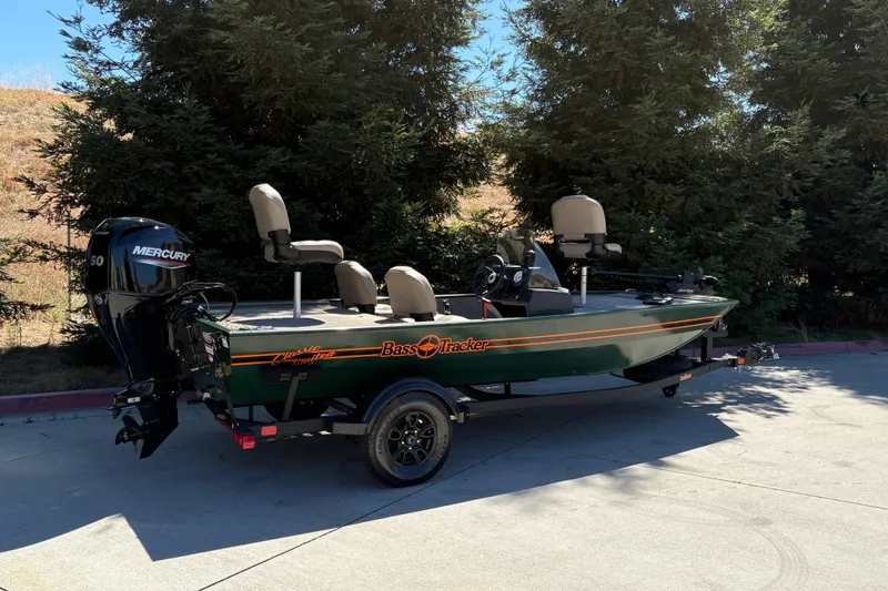 Slide: The Image of 2026 Tracker Bass Tracker Classic Limited boat with Mercury engine, parked outdoors. - 9