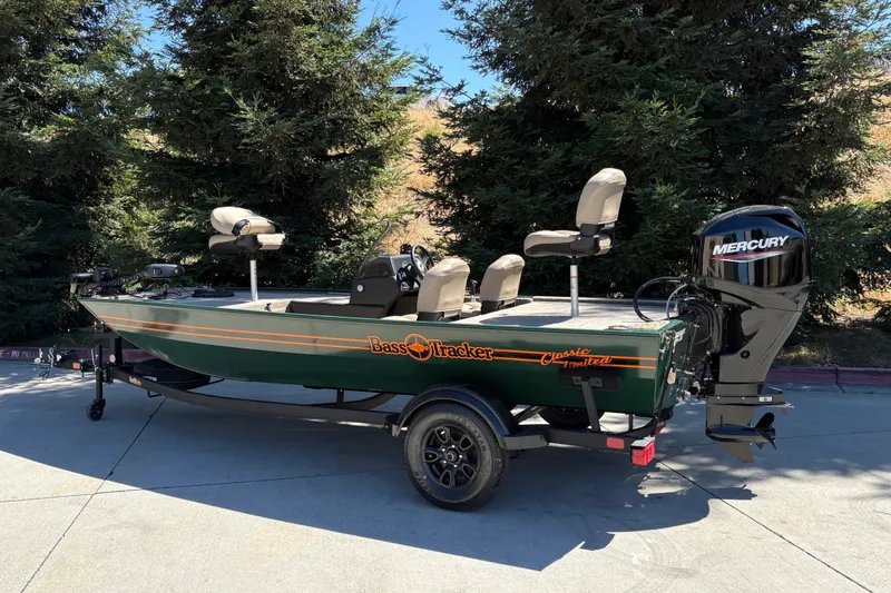 Slide: The Image of 2026 Tracker Bass Tracker Classic Limited boat with Mercury engine, parked outdoors. - 2