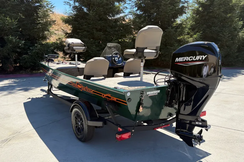 Slide: The Image of 2026 Tracker Bass Tracker Classic Limited boat with Mercury engine, parked outdoors. - 10