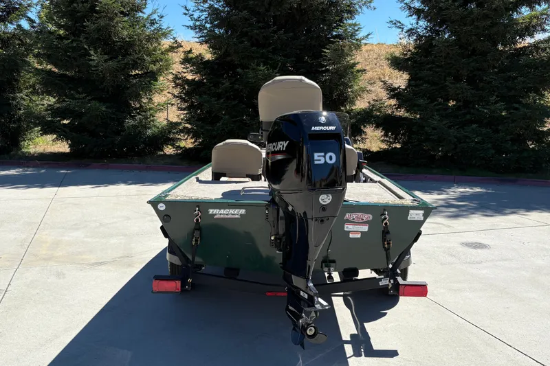 Slide: The Image of 2026 Tracker Bass Tracker Classic Limited boat with Mercury 50 engine, parked outdoors. - 11