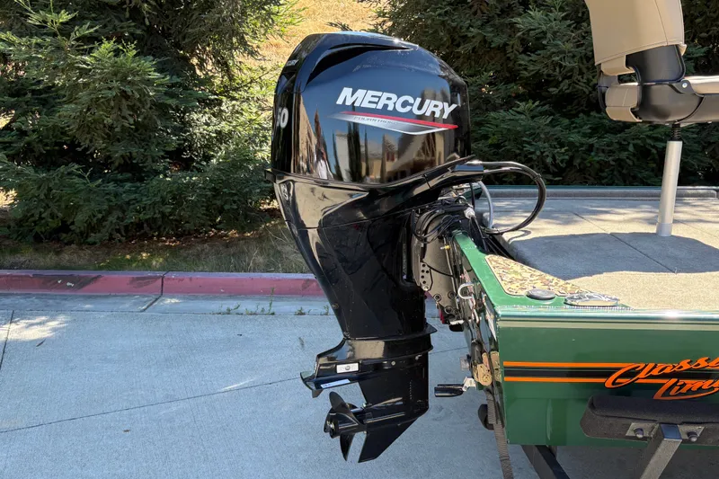 Slide: The Image of 2026 Tracker Bass Tracker Classic Limited with Mercury outboard motor, parked outdoors. - 12