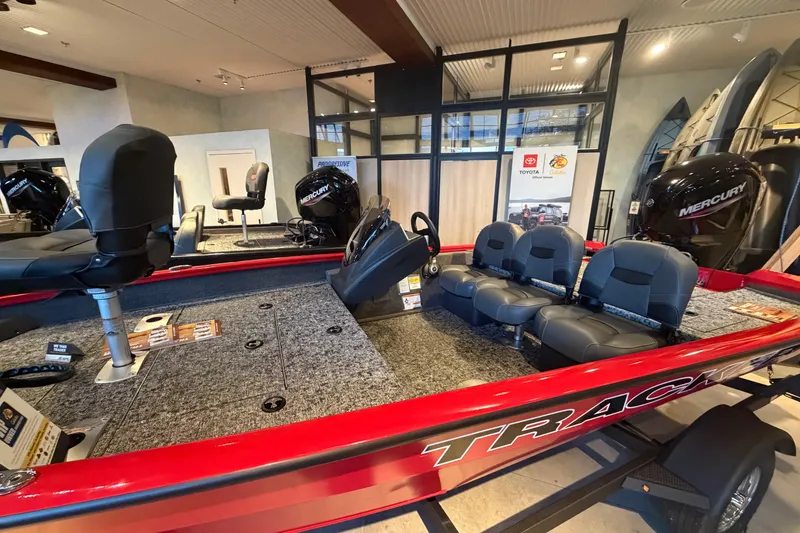 Slide: The Image of 2026 Tracker Pro Team 175 Crappie Edition boat with seating and Mercury engine in showroom. - 2
