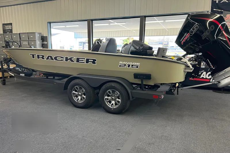 The Image of 2026 Tracker Savage 215 boat displayed indoors with trailer and powerful outboard motor. - 0