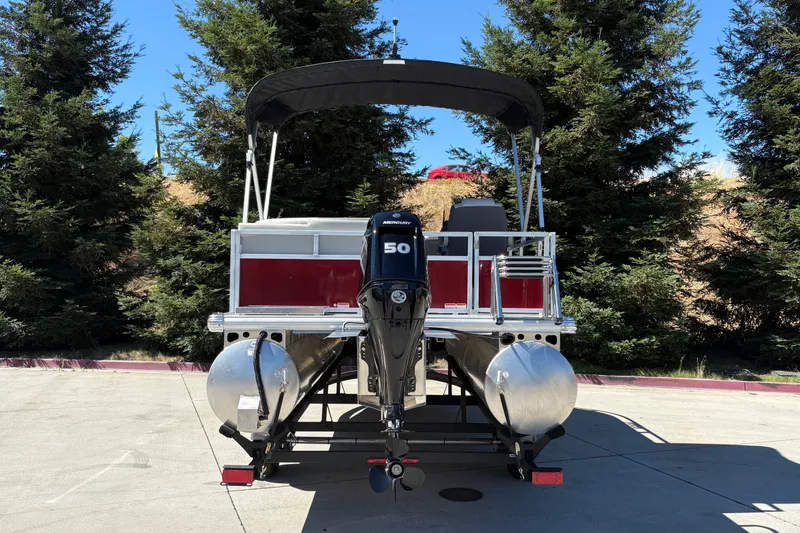 Slide: The Image of 2026 Sun Tracker Bass Buggy 16 XL Select pontoon boat with Mercury 50 engine, parked outdoors. - 15