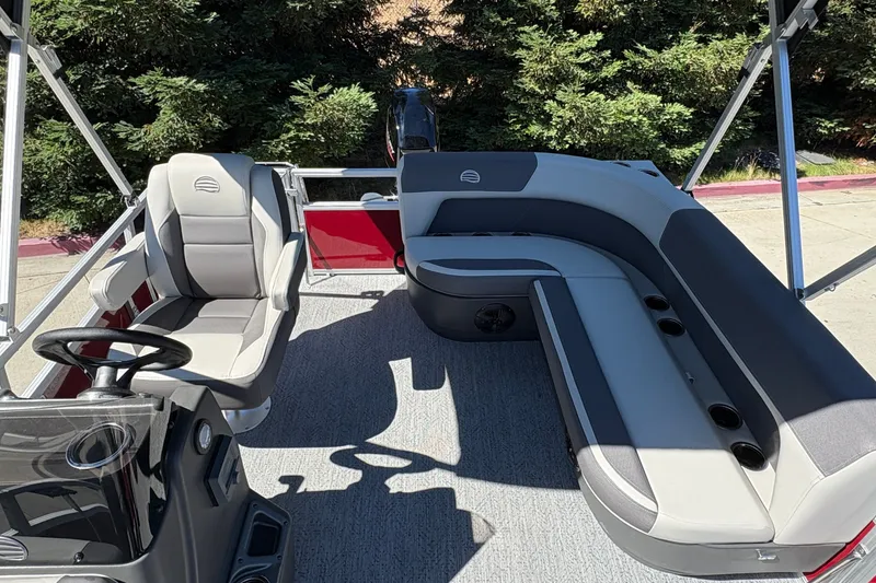 Slide: The Image of 2026 Sun Tracker Bass Buggy 16 XL Select pontoon boat interior with gray seating and steering console. - 18