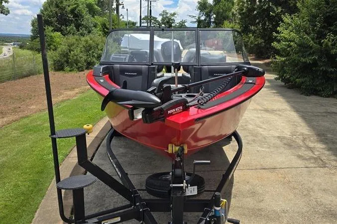 Slide: The Image of 2026 Tracker Targa V-18 Combo boat on trailer, parked outdoors, featuring a vibrant red exterior. - 2