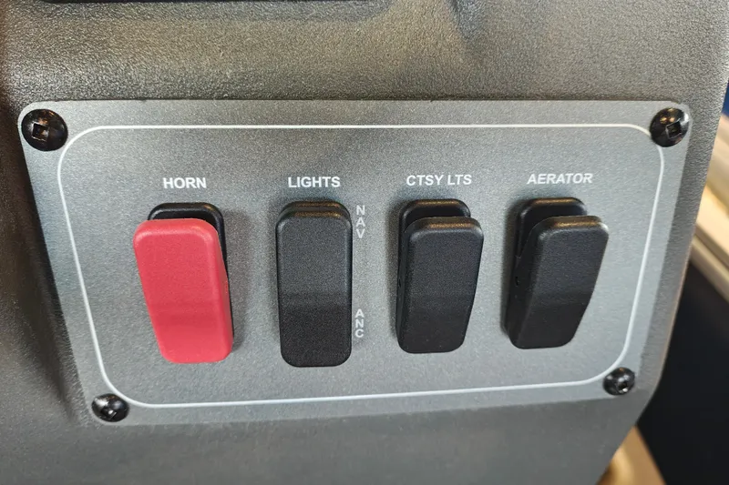 Slide: The Image of Control panel of 2026 Sun Tracker Bass Buggy 18 DLX with switches for horn, lights, courtesy lights, aerator. - 17