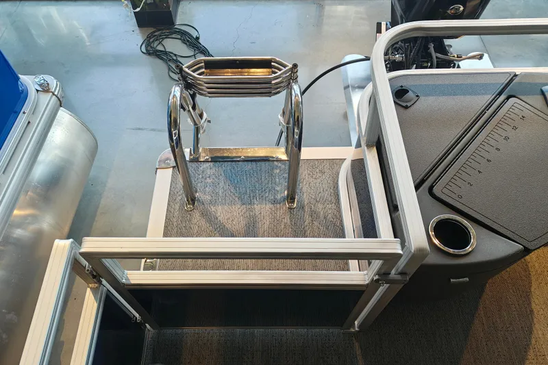 Slide: The Image of 2026 Sun Tracker Bass Buggy 18 DLX pontoon boat deck with ladder and storage. - 10